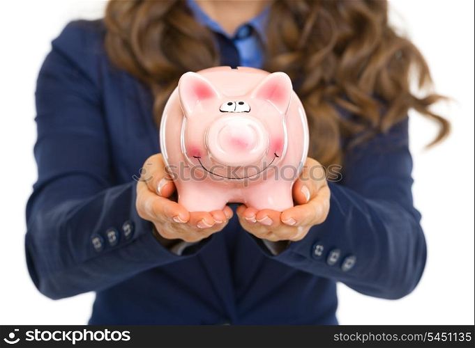 Closeup on business woman showing piggy bank