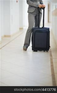 Closeup on business woman standing with wheel bag