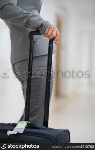 Closeup on business woman with bag on wheels