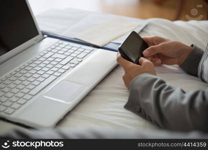 Closeup on business woman working on bed in hotel room