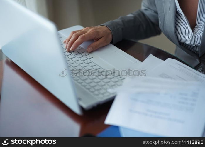 Closeup on business woman working with documents and laptop