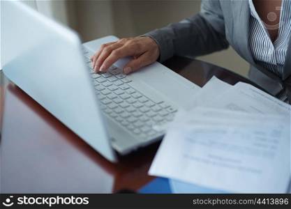 Closeup on business woman working with documents and laptop