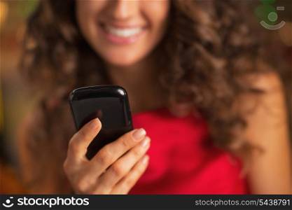Closeup on cell phone in hand of woman in red dress