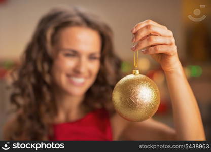 Closeup on christmas ball in hand of woman in red dress