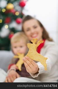 Closeup on Christmas deer shaped cookies in mother hand