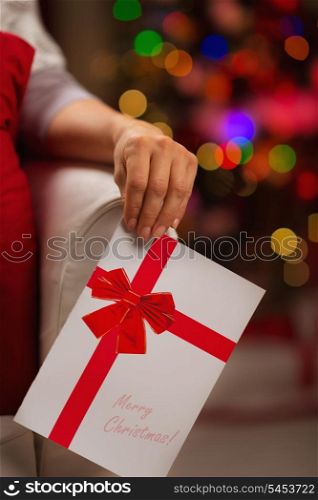 Closeup on Christmas postcard in woman hand
