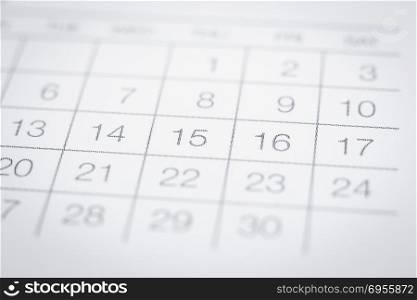 Closeup on dates of simple calendar page. Selective focus shown dot prints, blurred area on top and bottom. Black and white tone with modern minimal style. Work appointment, reminder and timetable.