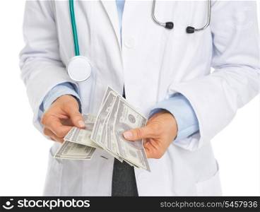 Closeup on doctor counting dollars