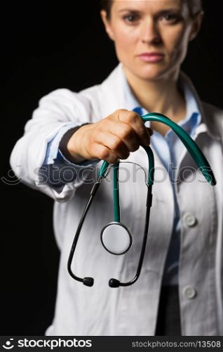 Closeup on doctor woman giving stethoscope isolated on black