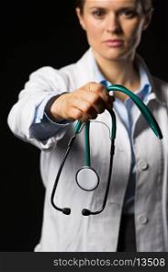 Closeup on doctor woman giving stethoscope isolated on black