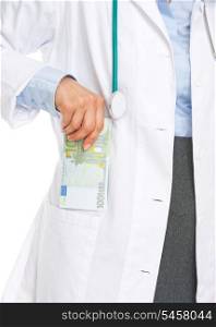 Closeup on doctor woman putting stack of euros in pocket