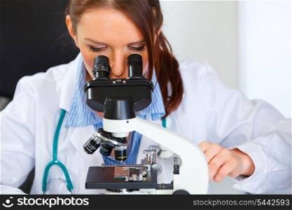 Closeup on doctor woman working with microscope in laboratory&#xA;