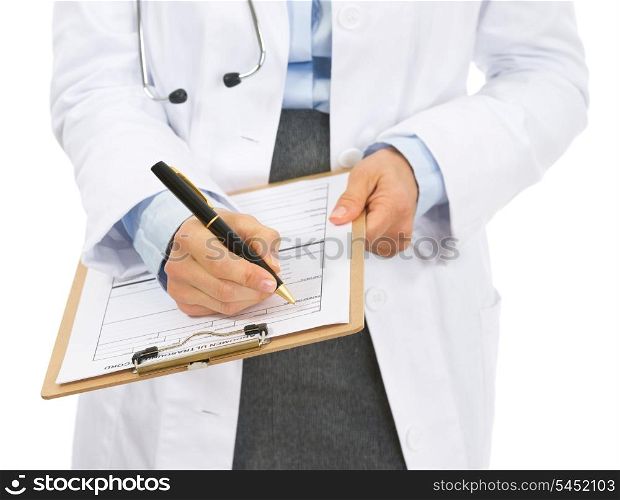 Closeup on doctor woman writing in clipboard