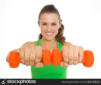 Closeup on dumbbells in hand of fitness young woman