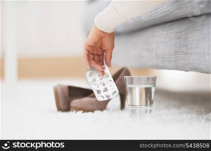 Closeup on empty medicine blister package in hand of young woman laying on couch