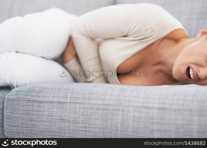 Closeup on feeling bad young woman laying on sofa