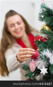 Closeup on female hand making decorating Christmas tree