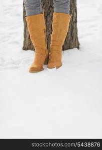 Closeup on female legs in winter boots on snow