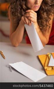 Closeup on frustrated young housewife with letter
