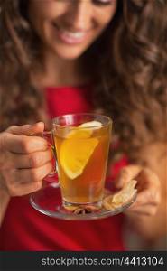 Closeup on ginger tea with lemon in hand of young woman