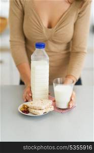 Closeup on glass of milk and crisp bread and woman in background