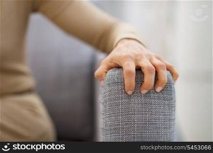 Closeup on hand of stressed woman sitting on divan