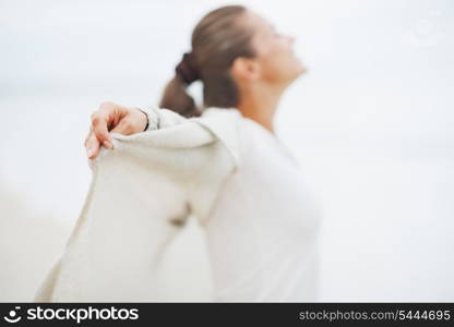 Closeup on hand of young woman in sweater on lonely beach