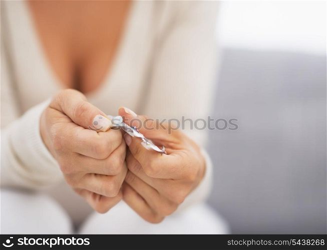 Closeup on hand pushing pill out of blister package