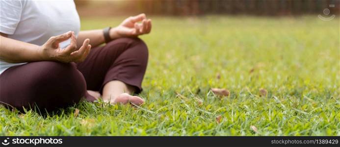 Closeup on hands. Asian Senior Woman in white shirt practicing Yoga at park. Meditation position with Copy space. Banner, Panoramic.
