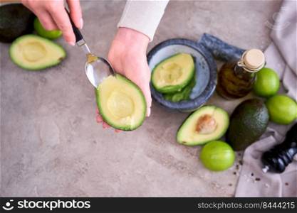 Closeup on hands holding fresh avocado cut in half making guacamole.. Closeup on hands holding fresh avocado cut in half making guacamole