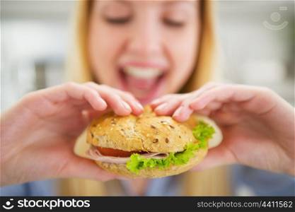 Closeup on happy young woman eating burger