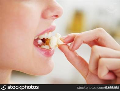 Closeup on happy young woman eating popcorn