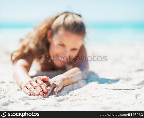 Closeup on happy young woman in swimsuit relaxing on beach