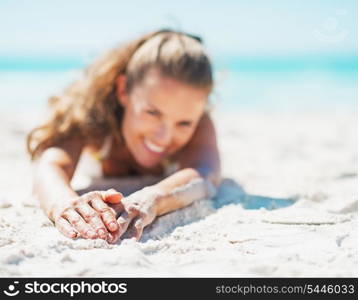 Closeup on happy young woman in swimsuit relaxing on beach