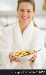 Closeup on healthy breakfast in hands of happy woman in bathrobe
