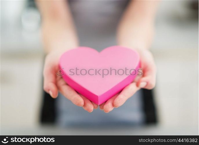 Closeup on heart in hand of young woman