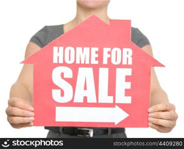 Closeup on home for sale sign in female hand. HQ photo. Not oversharpened. Not oversaturated. Closeup on home for sale sign in female hand isolated