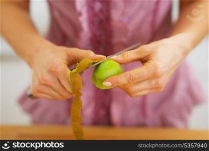 Closeup on housewife peeling kiwi