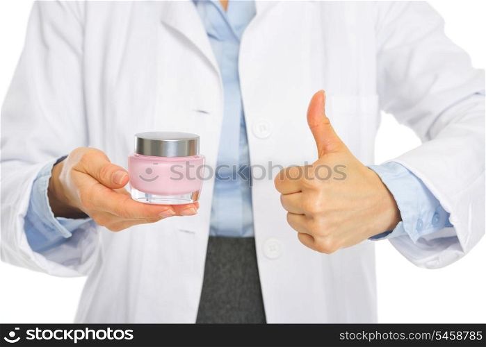 Closeup on kosmetist woman showing creme and thumbs up