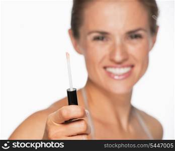 Closeup on lip gloss in hand of smiling woman