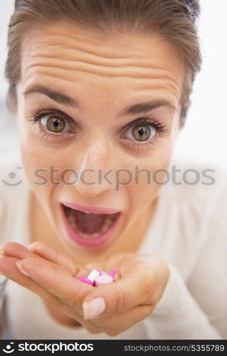 Closeup on mad woman eating handful of pills