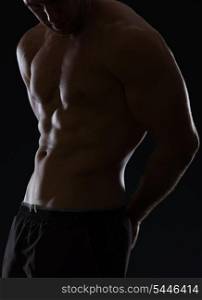 Closeup on male athlete showing muscular body on black