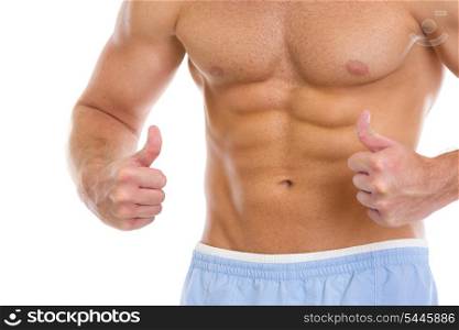Closeup on man with abdominal muscles showing thumbs up