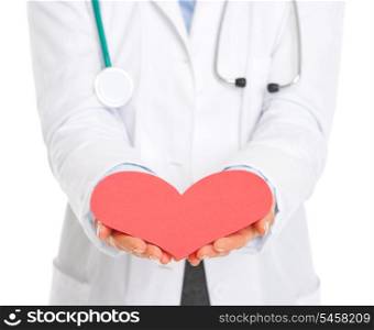 Closeup on medical doctor outstretching paper heart