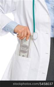 Closeup on medical doctor woman putting dollars in pocket