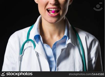 Closeup on medical doctor woman with tablet in mouth