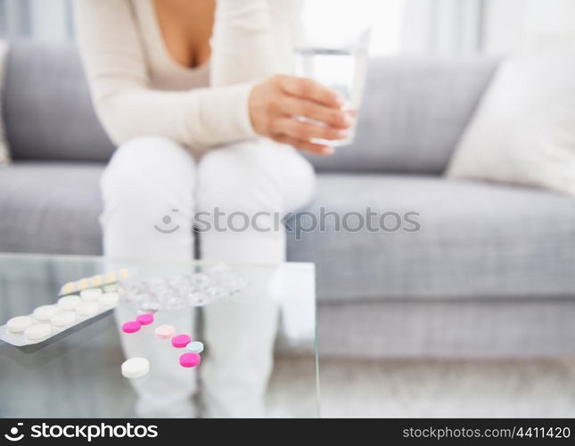 Closeup on medicine on table and young woman in background