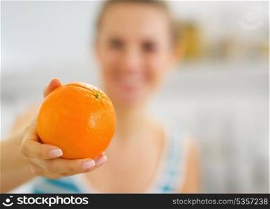 Closeup on orange in hand of young woman