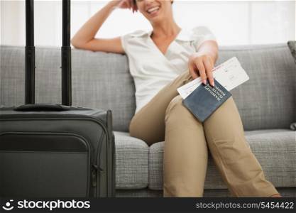 Closeup on passport and air ticket in hand of smiling young woman