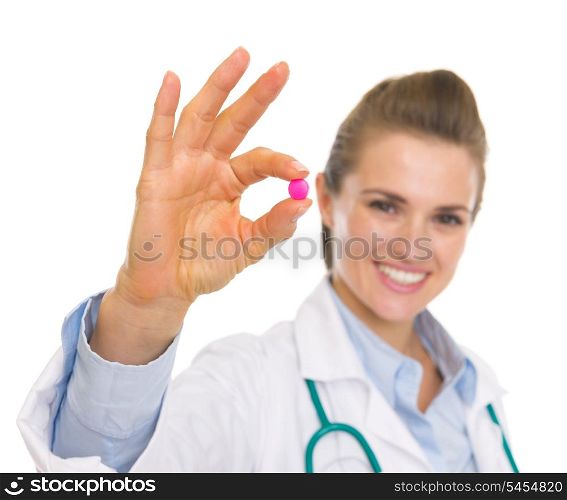 Closeup on pill in hand of happy doctor woman